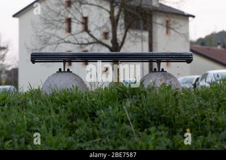 Banc déserté dans un parc en surcroissance au printemps dans un concept de lieux vides en raison du maintien du coronavirus ou de la pandémie de Covid-19 Banque D'Images