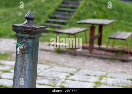 Fontaine d'eau et tables vides dans un parc urbain en gros plan avec espace de copie en raison du maintien du coronavirus ou de la pandémie de Covid-19 Banque D'Images