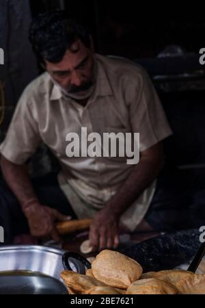 Un homme qui fait puri (poori) bhaji - un petit déjeuner traditionnel indien de rue - à Varanasi, Inde Banque D'Images