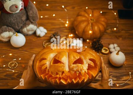 Homme regardant la citrouille orange lanterne de Jack pour des vacances d'automne traditionnelles Halloween. Banque D'Images