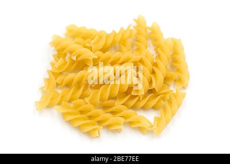 Pâtes fusilli maison tas sur fond blanc isolé dans la vue de dessus macro. Les fusilli ont une forme spirale et une couleur jaune. Les pâtes sont un délicieux tra italien Banque D'Images