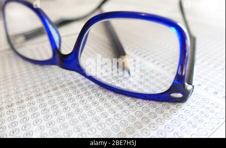 Crayon et lunettes sur la feuille de réponse - examen de test Banque D'Images