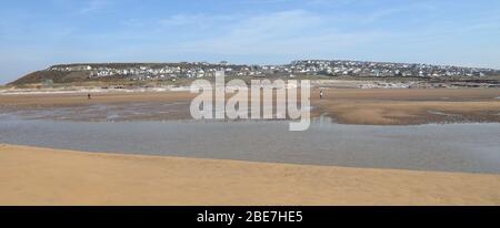 Le village de Hillside d'Ogemore par mer avec sa vaste plage de sable à marée basse montrant des rochers et des maisons au loin. Banque D'Images