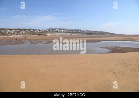 Le village de Hillside d'Ogemore par mer avec sa vaste plage de sable à marée basse montrant des rochers et des maisons au loin. Banque D'Images