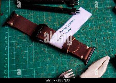 Bracelet de montre en cuir, travail avec étiquette blanche sur carton vert Banque D'Images