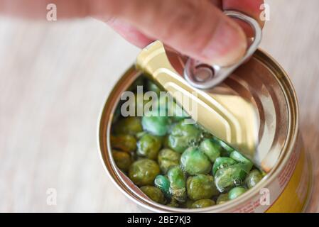 Ouvrir les aliments en conserve en métal sur fond de bois / gros pois conserves de marchandises non périssables stockage des aliments dans la maison de cuisine Banque D'Images