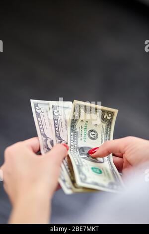 Une femme tient de l'argent entre ses mains. L'économie et les marchés financiers affectés par le coronavirus. Économisez de l'argent. Banque D'Images