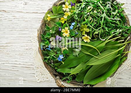 Ingrédients alimentaires sains de printemps. Le Dandelion frais cueilli, la fleur, l'ail sauvage et les feuilles d'ortie cueillies dans le fond de panier Banque D'Images