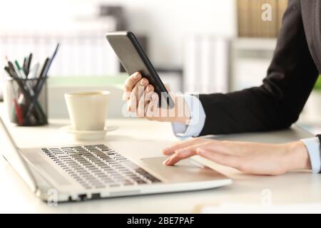 Gros plan sur les mains des femmes d'affaires à l'aide de multiples appareils installés sur un bureau Banque D'Images