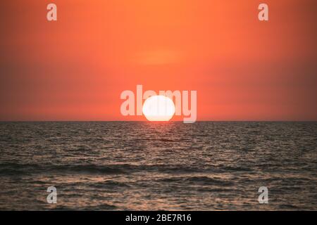 Coucher de soleil soleil couleur naturelle ciel sur la mer. Seascape avec Shining Setting Sun on Sea Horizon. Banque D'Images
