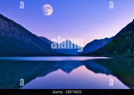 Lac Plansee avec pleine lune, ambiance de soirée, Alpes d'Ammergau, derrière la montagne Thangeller dans les Alpes de Lechtal, Tyrol, Autriche Banque D'Images