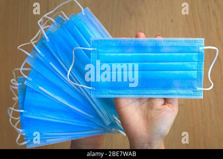 Masques de protection jetables à usage médical à portée de main Banque D'Images