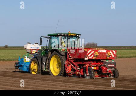 2018 accessoire John Deere Tracotr & Grimme Malpas vert plantant des pommes de terre de semence à Tarleton. Après une nuit froide avec un léger gel, les sols sont en bon état pour le labourage et la formation des rainures profondes à sillons à des fins de drainage, pour permettre la plantation par ressort de récoltes agricoles à l'aide d'un accessoire Grimm Malpas et d'un engrais avant avec un tracteur John Deere 6135R. Les cultures principales ou les terres d’arais comprennent des pommes de terre de type «maris Piper» et prennent de 16 à 22 semaines pour mûrir. Les pommes de terre de semence sont prêtes à planter lorsque les pousses «chit» après qu'elles commencent à gercer Banque D'Images