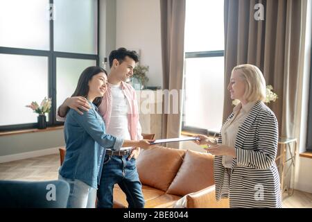 Soutien psychologique. Homme grand aux cheveux sombres et sa petite amie parlent au psychologue Banque D'Images