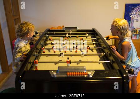 Un frère et une sœur s'amusent à jouer au baby-foot à Etel, en France. Banque D'Images