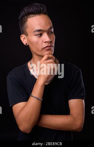 Portrait of young handsome Indian man thinking Banque D'Images