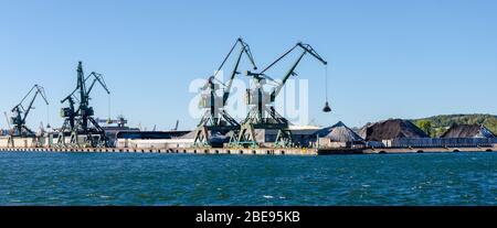 Grues et piles de charbon dans un port de charbon à Gdynia, Pologne. Banque D'Images