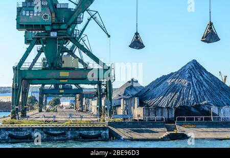 Grues et piles de charbon dans un port de charbon à Gdynia, Pologne. Banque D'Images