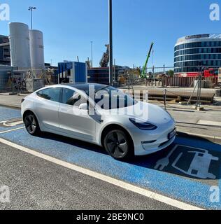 Une voiture électrique Tesla modèle 3 recharge les batteries Banque D'Images