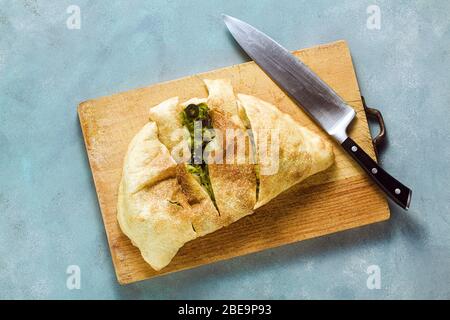 Calzone pizza italienne avec herbes fraîches et herbes. Nourriture saine Banque D'Images