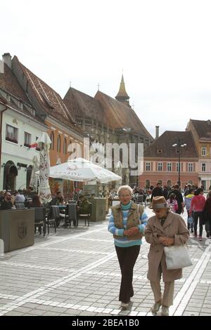 Brasov, Roumanie. Visiteurs sur la place de la salle (Piata Sfatului), le centre de la vieille ville. Banque D'Images