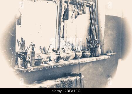 Photo ancienne de style vintage. Seuil de fenêtre sur lequel se tiennent des outils vases dans la poterie Banque D'Images