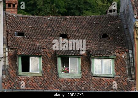 Toit en carrelage d'origine avec fenêtres mansardées dans la vieille ville historique de Brasov, Roumanie Banque D'Images