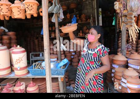 Colombo, Sri Lanka. 13 avril 2020. Une femme vend des pots et des casseroles d'argile pendant la nouvelle année.cinhala le nouvel an tamoul est marqué pendant le gouvernement a mis en place un couvre-feu à l'échelle de l'île afin de ralentir la propagation du coronavirus du SRAS-COV-2. Crédit: SOPA Images Limited/Alay Live News Banque D'Images