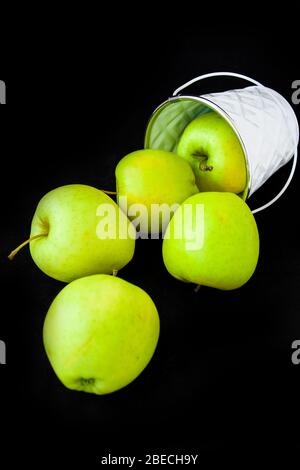 Un groupe de Granny Smith et de pommes dorées dans un seau blanc sur un fond brun foncé, copier l'espace pour le texte Banque D'Images