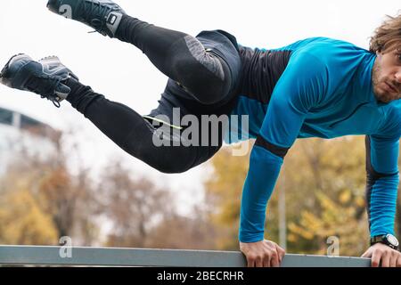 Image recadrée d'un sportif qui s'exerce à l'extérieur, sautant Banque D'Images