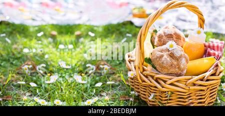 Déjeuner dans le parc sur l'herbe verte. Journée ensoleillée d'été et panier pique-nique. Sandwichs, hamburgers pour la nourriture de rue à l'extérieur. Espace de copie. Bannière. Mise au point douce, ci-dessus Banque D'Images