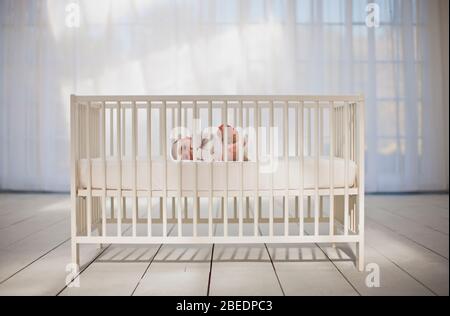 Un petit garçon mignon allongé sur son côté dans un lit de bébé Banque D'Images