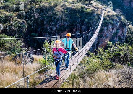 Père et fils sur un pont de randonnée qui s'étend sur le Cañon Aguila Cola Roja (Red Tait Eagle Canyon) près de San Miguel de Allende, Mexique. Banque D'Images