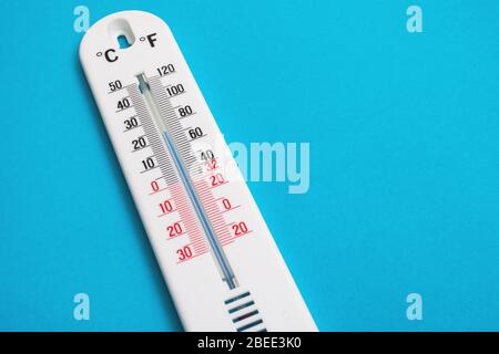 Thermomètre blanc sur fond bleu Banque D'Images