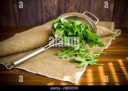 une roquette dans une passoire sur une table en bois Banque D'Images