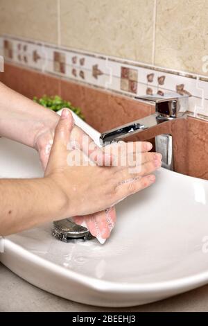 Hygiène. Mains de nettoyage. Laver les mains avec du savon. Jeune femme se laver les mains avec du savon sur évier dans la salle de bains, se rapprochez. Covid 19. Coronavirus. Banque D'Images