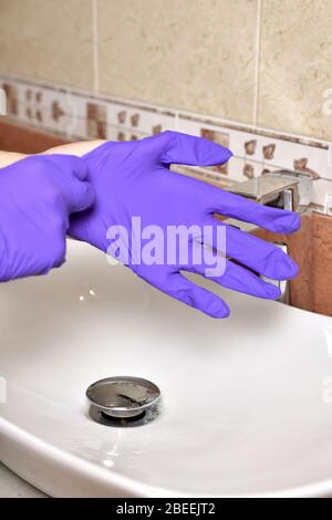 girl met des gants de protection pendant l'épidémie de coronavirus. l'utilisation de gants de protection dans une épidémie. protection contre le coronavirus covid-19 Banque D'Images