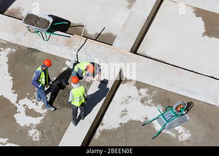 Les travailleurs en uniforme sable propre sur un site de construction, vue d'en haut. Banque D'Images