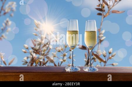 Deux verres de vin mousseux avec fleurs blanches fleuries fond. Thème mariage et célébration. Banque D'Images