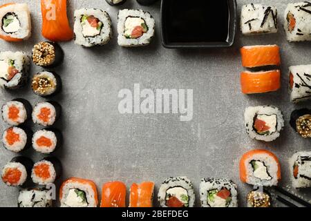 Plat avec rouleaux à sushi sur fond gris, espace pour le texte Banque D'Images