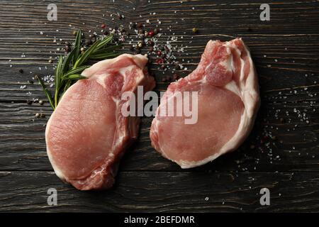 Composition avec viande crue pour steak et épices sur fond de bois Banque D'Images