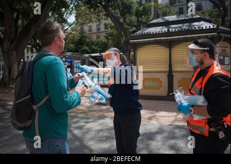 Un membre de la protection civile espagnole donne un masque facial à un citoyen comme mesure préventive contre la propagation de Covid-19 pendant un verrouillage. Des milliers d'Espagnols reprennent leur emploi après avoir terminé l'arrêt de toutes les activités et services de travail non essentiels et de revenir à l'état d'alarme original et de verrouillage depuis le début de l'éclosion de coronavirus (COVID-19) en Espagne. Tous les gens sont fermés dans leur maison après le confinement décrété par le gouvernement espagnol et qui sera prolongé jusqu'au 10 mai. Banque D'Images