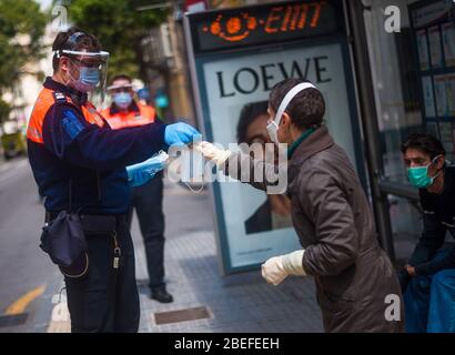 Un membre de la protection civile espagnole donne un masque facial à un citoyen comme mesure préventive contre la propagation de Covid-19 pendant un verrouillage. Des milliers d'Espagnols reprennent leur emploi après avoir terminé l'arrêt de toutes les activités et services de travail non essentiels et de revenir à l'état d'alarme original et de verrouillage depuis le début de l'éclosion de coronavirus (COVID-19) en Espagne. Tous les gens sont fermés dans leur maison après le confinement décrété par le gouvernement espagnol et qui sera prolongé jusqu'au 10 mai. Banque D'Images