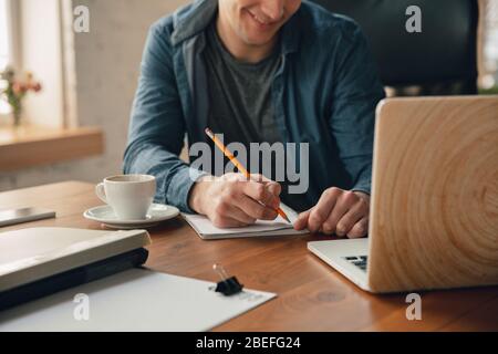 Espace de travail créatif - espace de travail organisé comme vous le souhaitez pour vous inspirer. Homme travaillant au bureau dans une tenue confortable, une position détendue et une table désordonnée. Choisissez l'atmosphère que vous voulez - idéal clair ou chaos. Banque D'Images