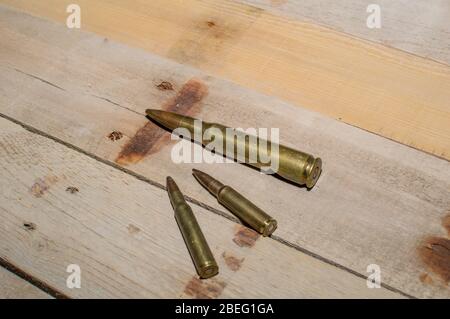 Trois cartouches de calibre fusil différentes sur bois de grange. Banque D'Images