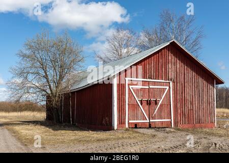 Grange ou hangar d'ocre rouge dans la campagne rurale. Tuusula, Finlande. Banque D'Images