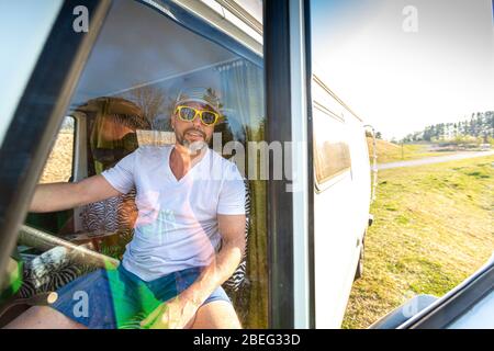 Portrait de l'homme avec lunettes de soleil pendant les vacances dans sa camionnette Banque D'Images