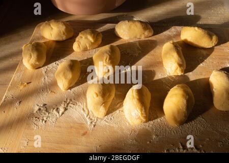 Tartes de pommes de terre au chou avant de cuire sur un tableau de découpe. Banque D'Images