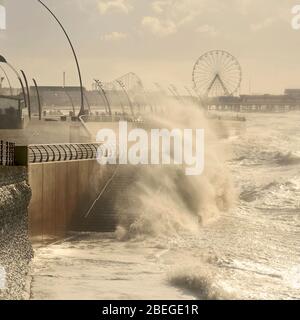 Les vagues se brisent sur le sentier côtier sur un front de mer vide pendant les temps sauvages et venteux à Blackpool Banque D'Images