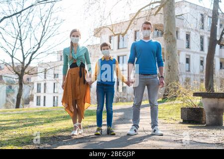 Famille ayant une promenade au soleil pendant l'urgence du coronavirus Banque D'Images